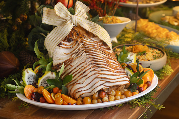 Peru inteiro fatiado acompanhado de cebolas caramelizadas, frutas cítricas e seu próprio molho