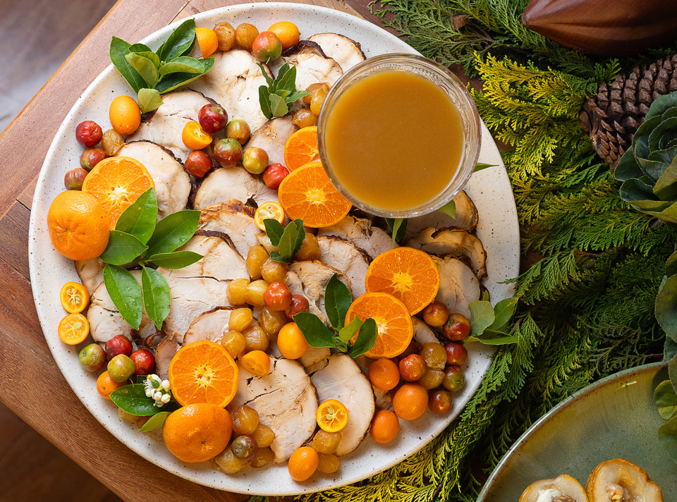 Peru fatiado acompanhado de cebolas caramelizadas, frutas cítricas e seu próprio molho