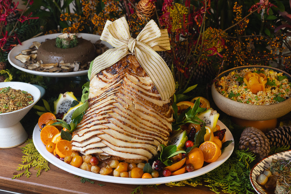 Peru inteiro fatiado acompanhado de cebolas caramelizadas, frutas cítricas e seu próprio molho