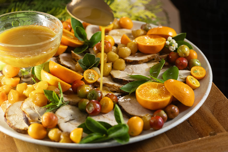 Peru fatiado acompanhado de cebolas caramelizadas, frutas cítricas e seu próprio molho