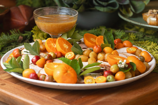 Peru fatiado acompanhado de cebolas caramelizadas, frutas cítricas e seu próprio molho