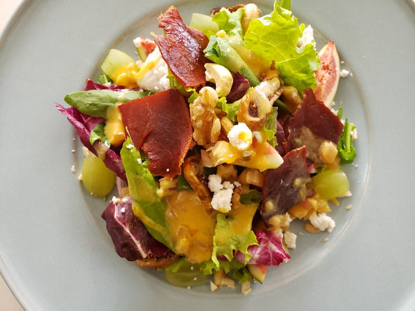 Salada de folhas com figos secos, queijo de cabra, presunto cru e molho de mostarda